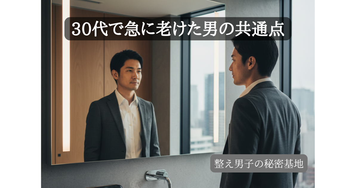 モダンな洗面所の鏡に向かい、自分の表情を冷静にチェックする30代の日本人ビジネスマン。清潔感のあるスーツ姿と整った髪型が、セルフマネジメントによる『老け見え脱出』を象徴している。背景には都会的な高層ビルが見え、洗面台にはコーヒーカップとケア用品が置かれている。