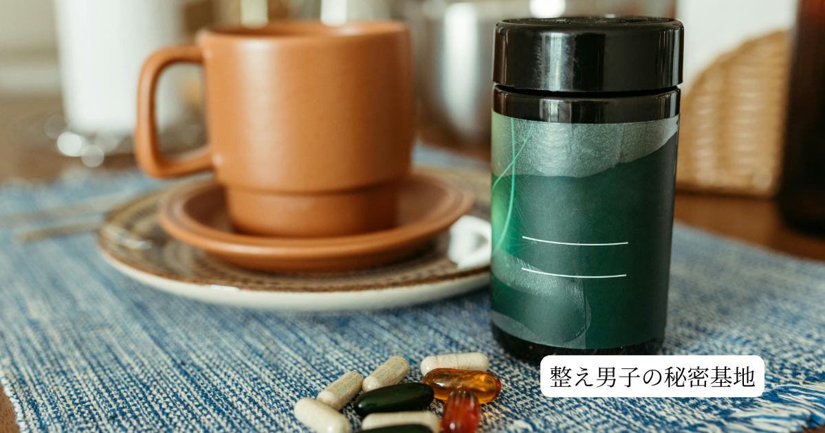 仕事の質を上げる必須栄養素の補給をイメージした、デスク上のプロテインシェイカーとサプリメントボトル、コーヒーの配置